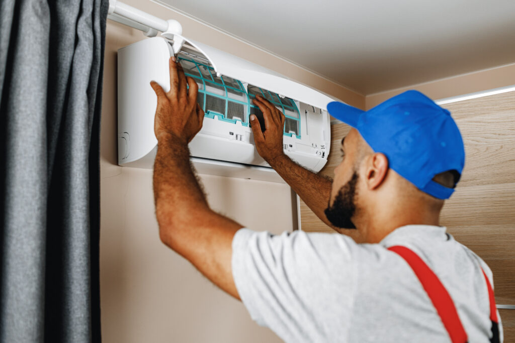 Professional repairman installing air conditioner in a room